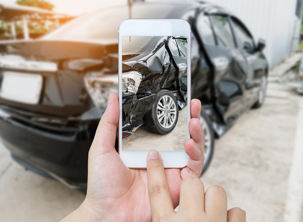 Someone taking a photo of a damaged car